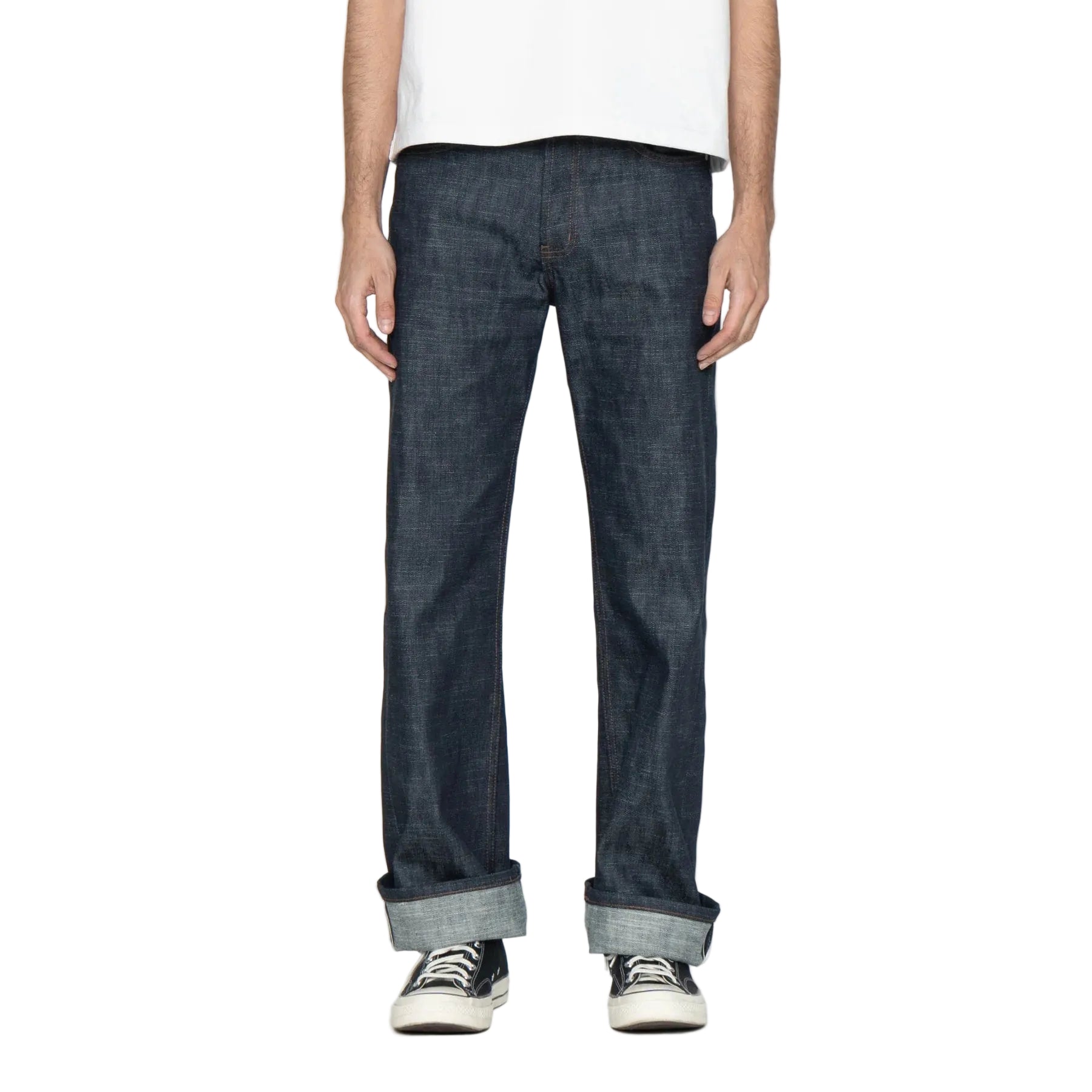 Person wearing dark blue jeans with a plain background