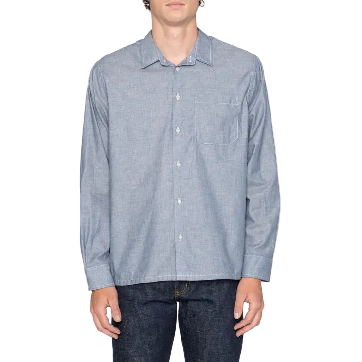 Man wearing a light blue striped shirt and dark jeans on a white background