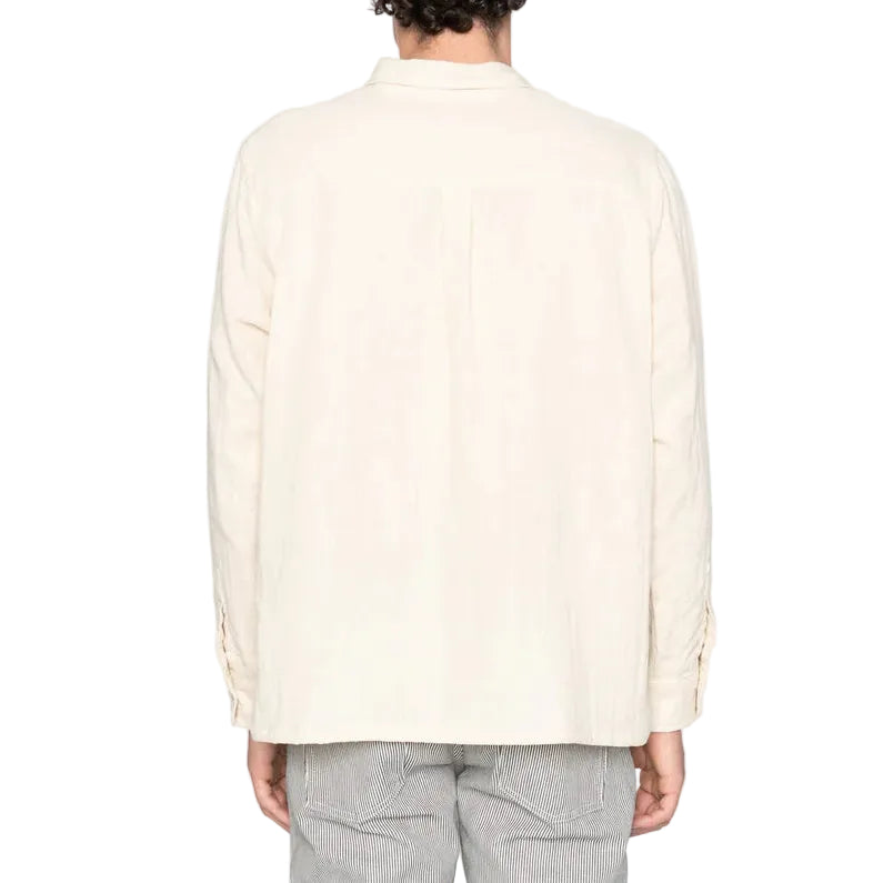 Person wearing a light-colored shirt on a white background