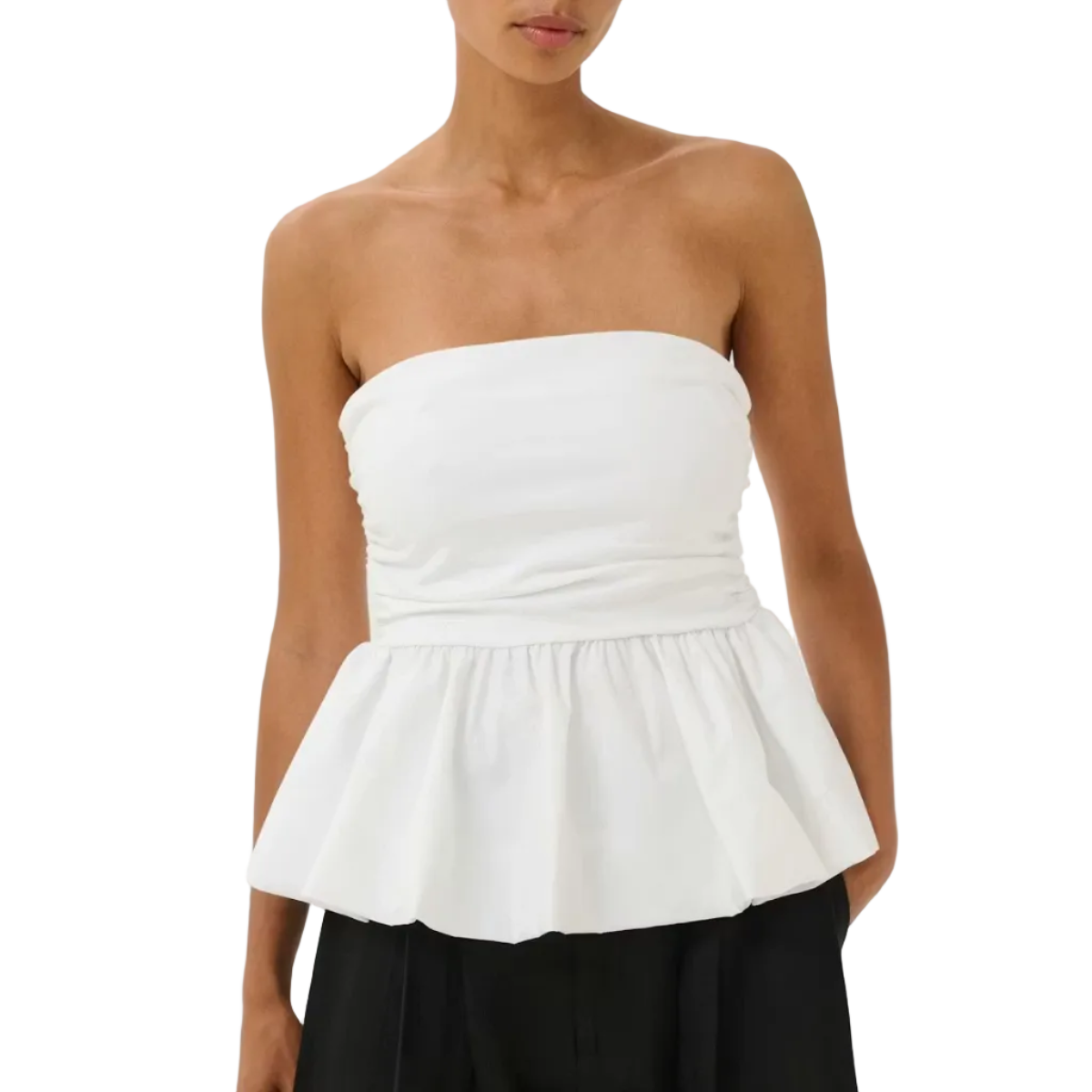Woman wearing a white peplum top and black pants on a white background