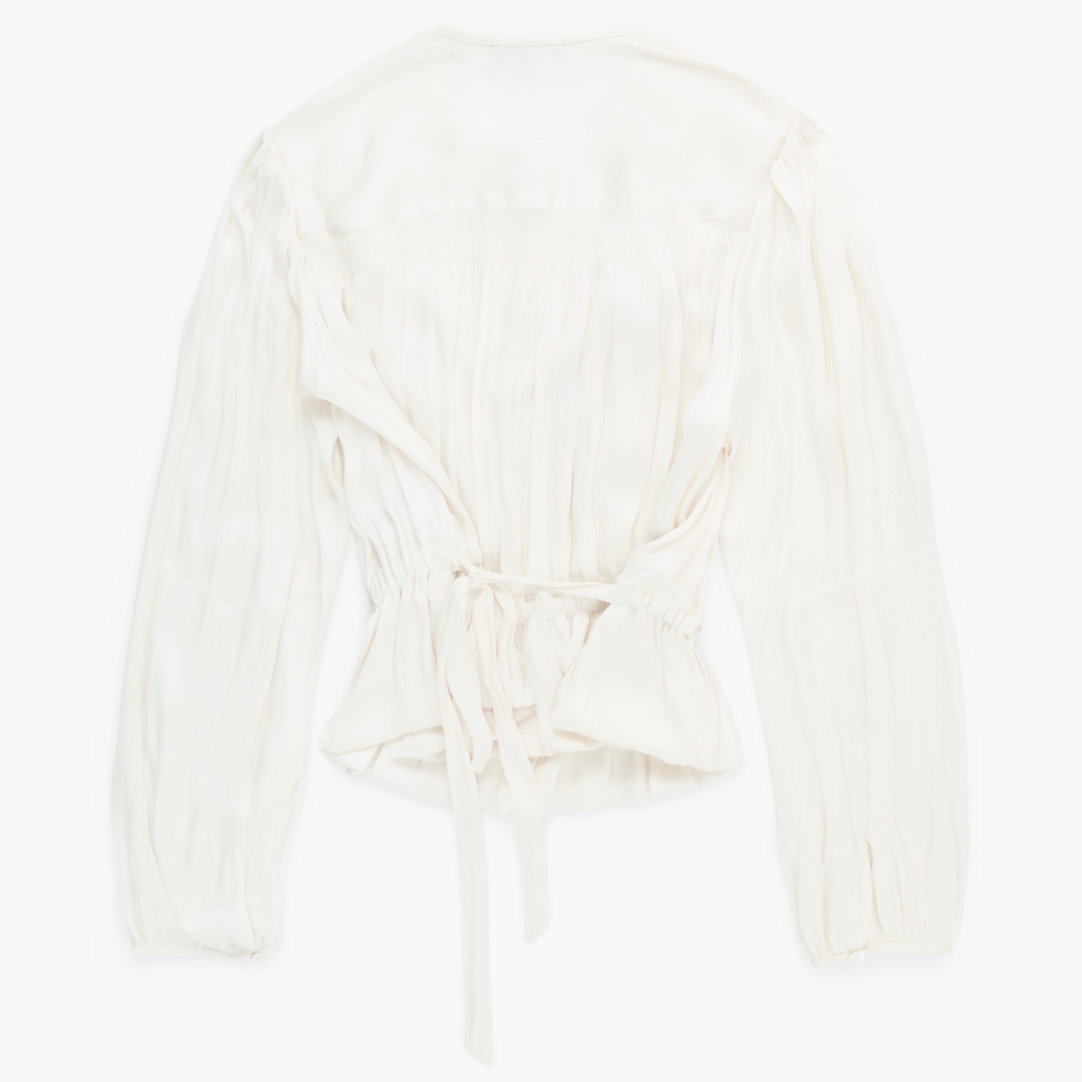 White blouse on a white background; back view