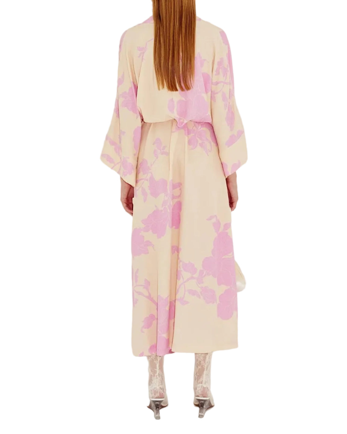 Person in a beige kimono style dress with a pink floral pattern on a white background