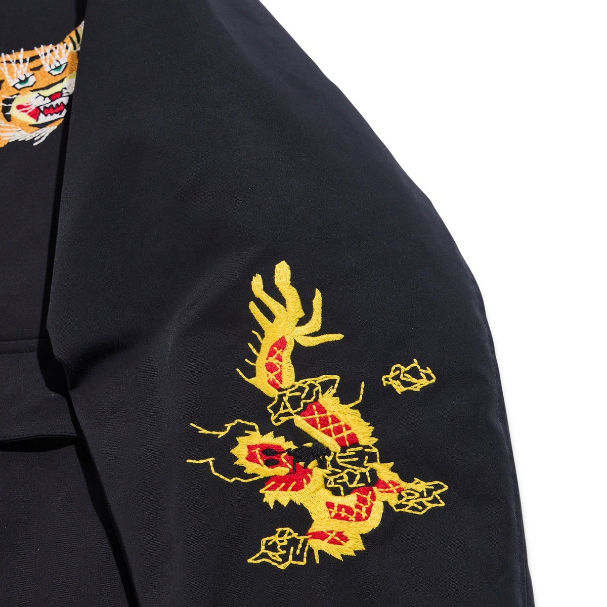 Black garment with a yellow and red dragon embroidery on a white background
