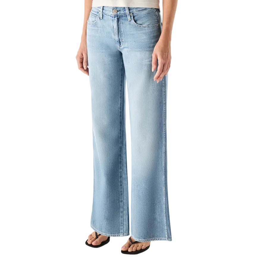 Person wearing light blue jeans and a white top on a plain background