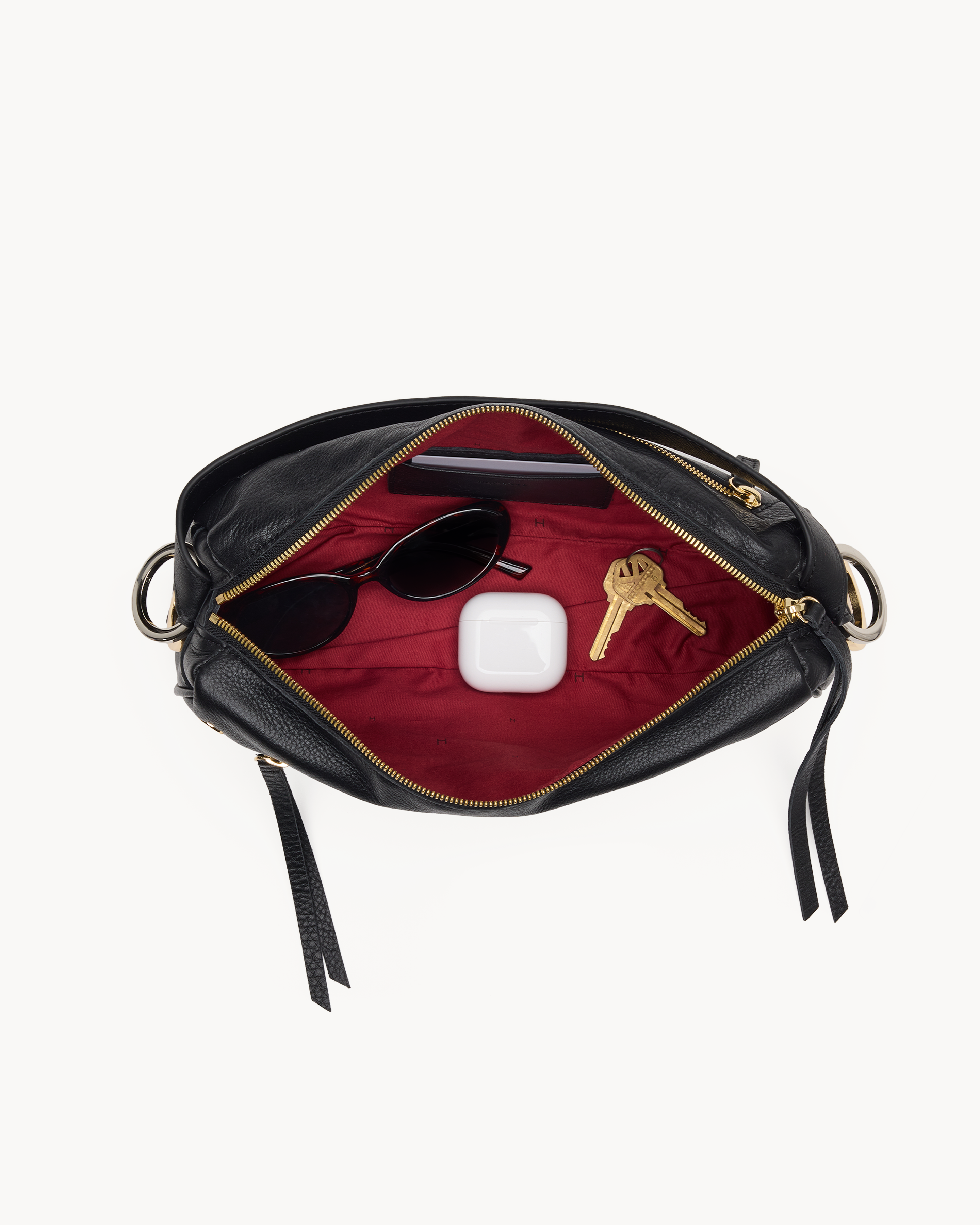 Interior view of a black handbag with gold accents on a white background