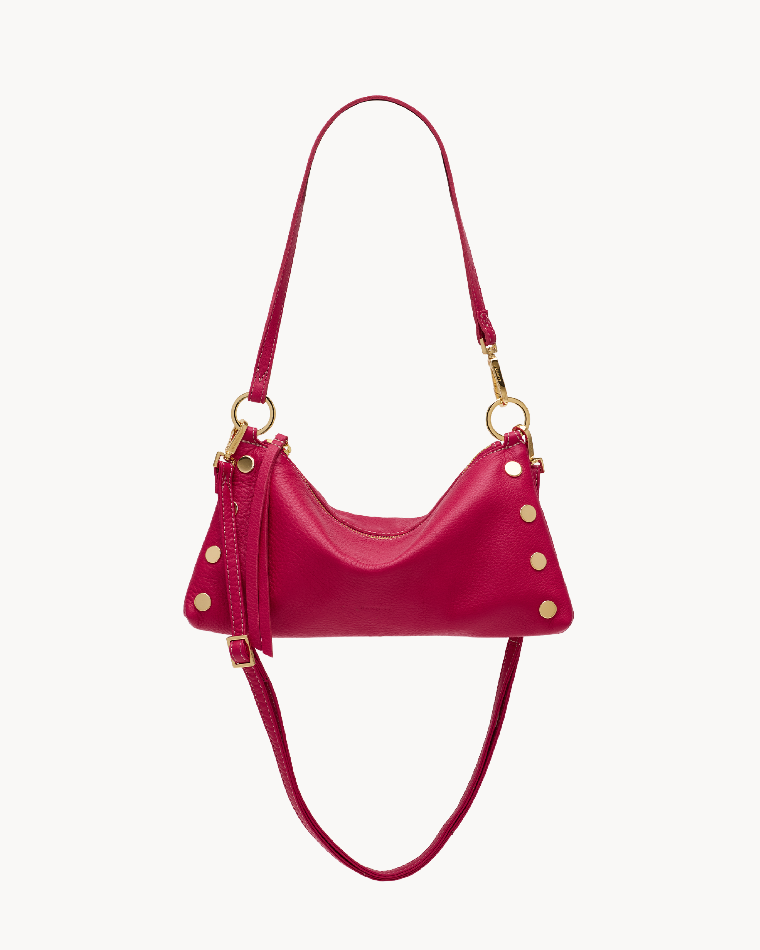 Magenta leather convertible bag with gold accents on a white background