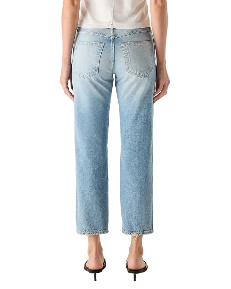 Person wearing a white t-shirt and light blue jeans on a white background
