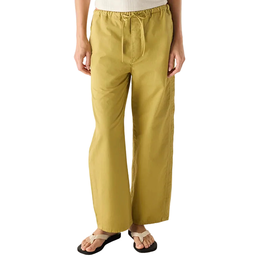 Person wearing a white top and mustard yellow pants on a white background
