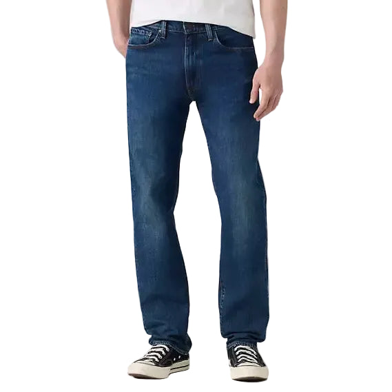 Man wearing a white t-shirt and blue jeans on a plain background