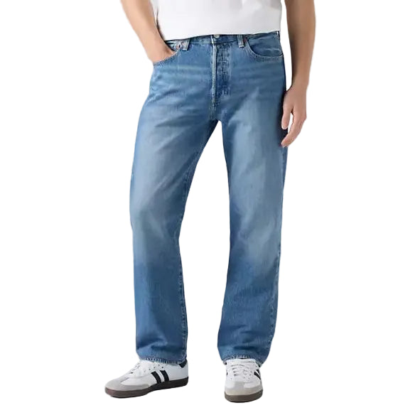 Man wearing a white t-shirt and blue jeans on a plain background