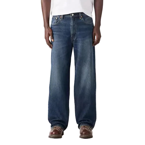 Man wearing a white t-shirt and blue jeans on a white background