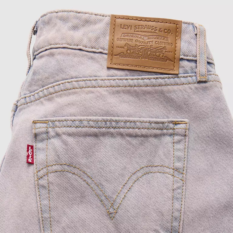 Close-up of Levi's jeans with brand label and pocket detail on a light background