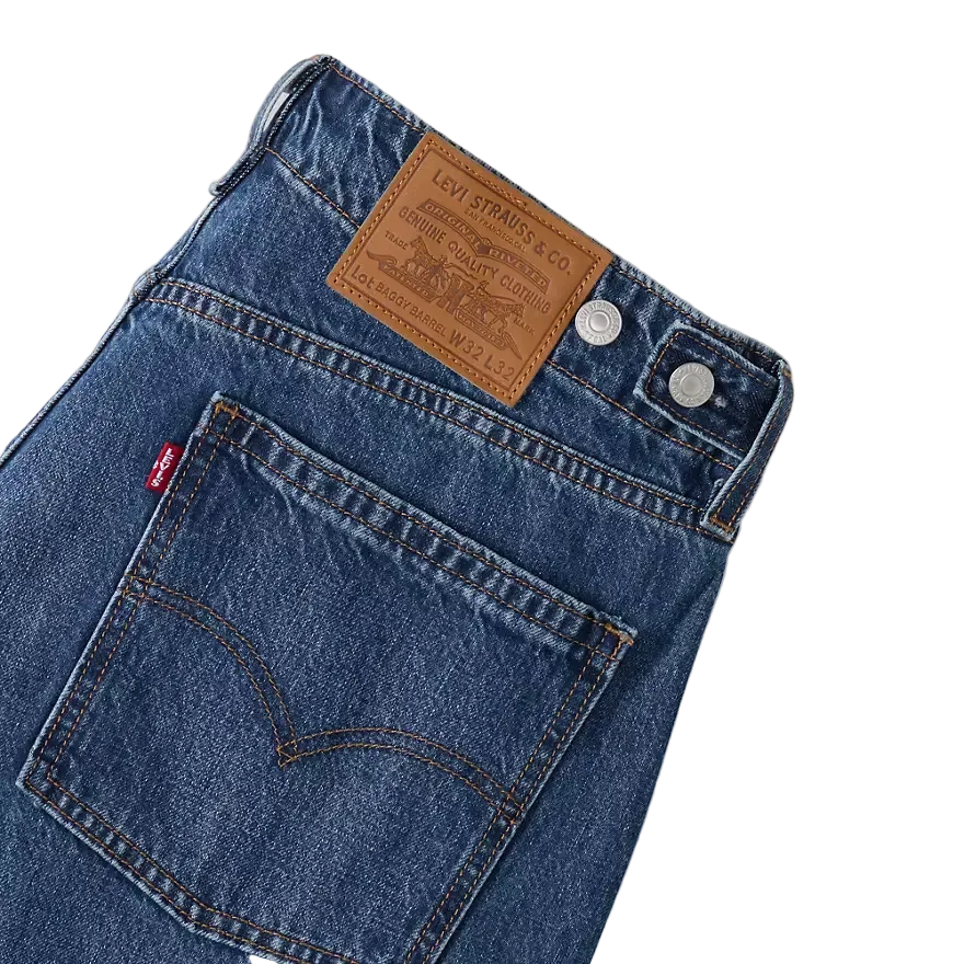 Close-up of blue jeans with Levi's logo and label on a white background