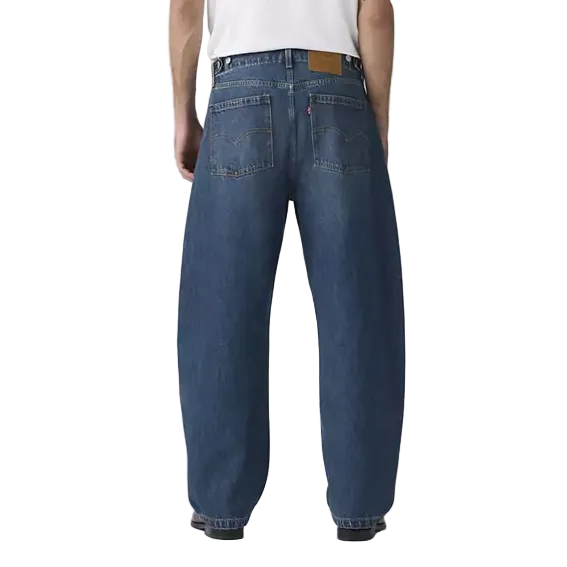 Person wearing blue jeans and a white t-shirt on a plain background