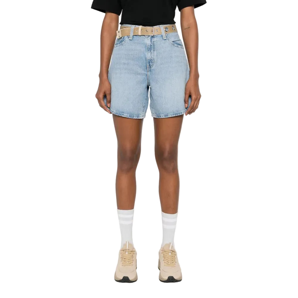 Person wearing a black t-shirt, light blue denim shorts, and white socks with a white background