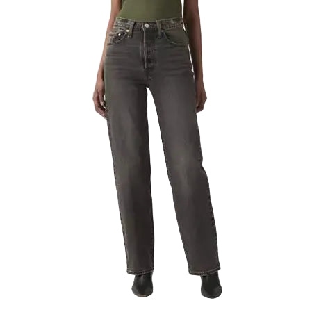 Woman wearing a green top and dark jeans on a white background