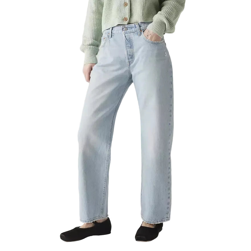 Person wearing light blue jeans on a plain background