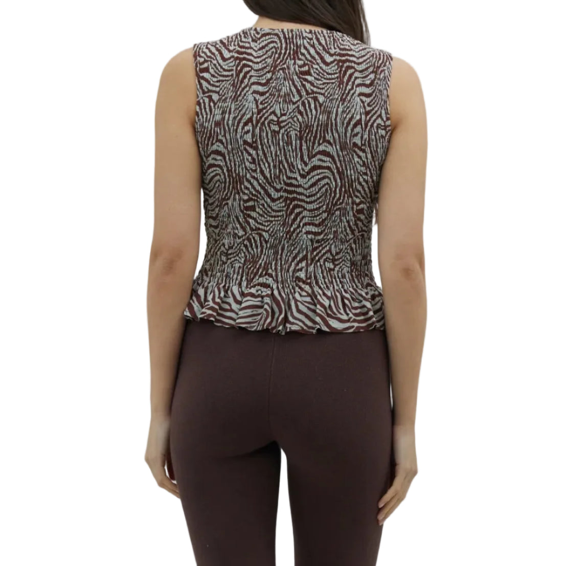 Woman wearing a patterned sleeveless top and brown capri pants on a white background