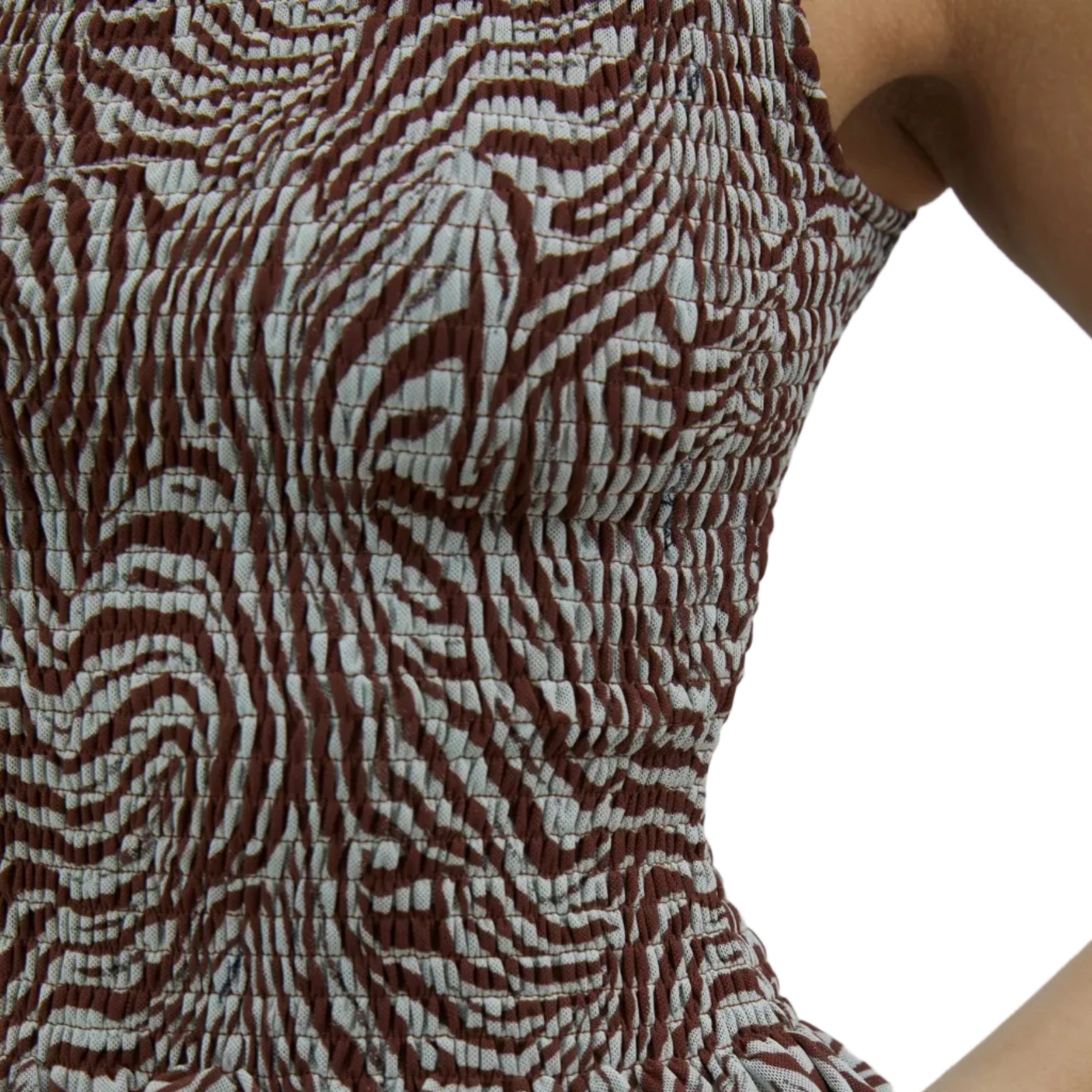 Close-up of a sleeveless top with a brown and white pattern on a neutral background