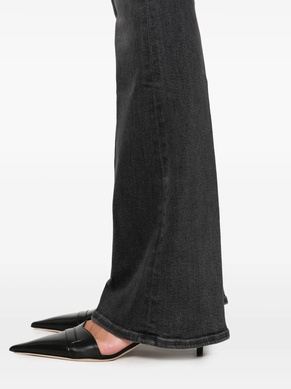 Black jeans worn by a person on a white background