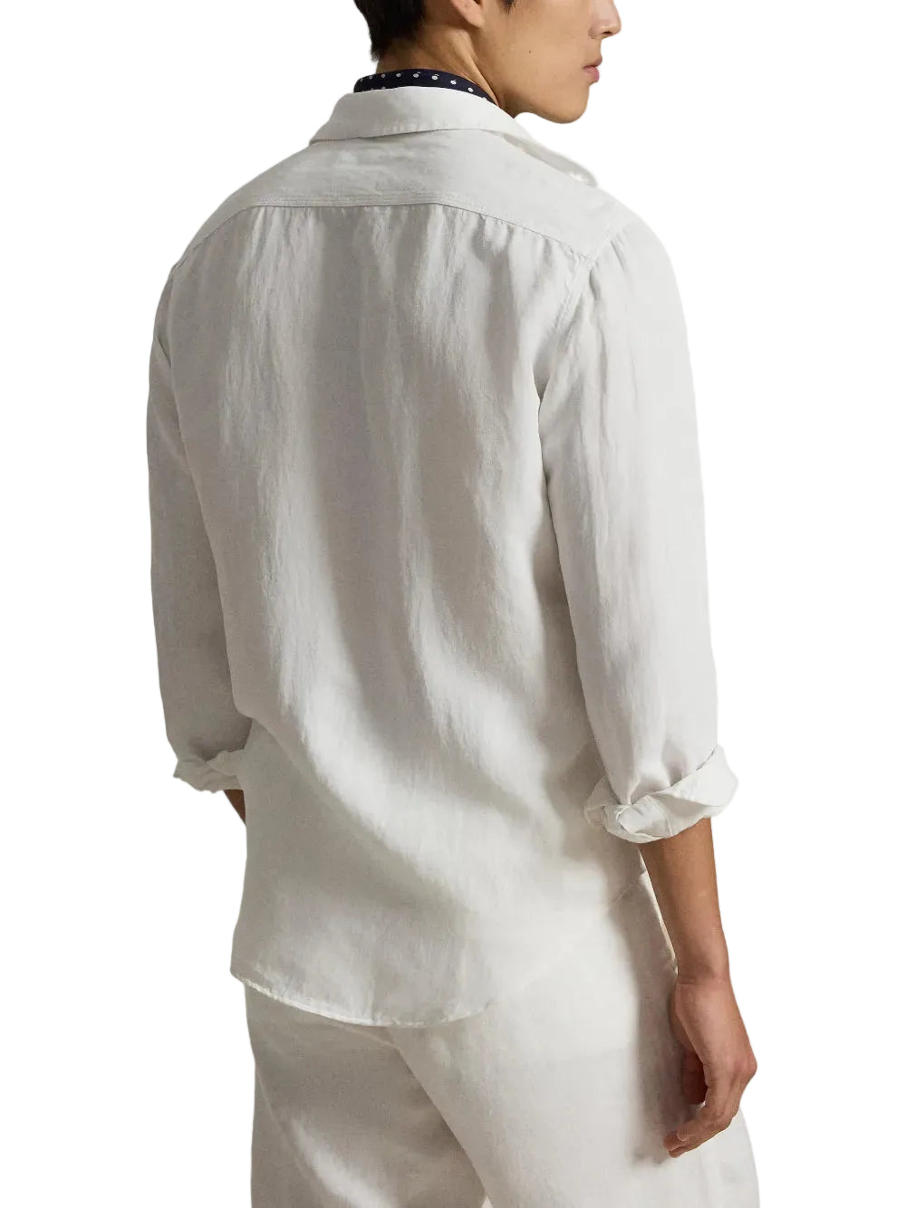 Person in a white workshirt with a blue scarf on a white background