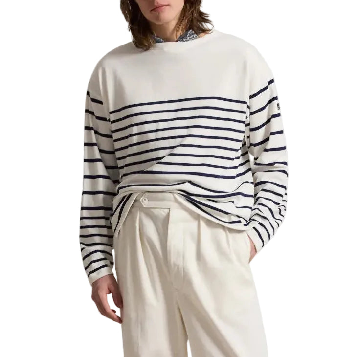 Person in a white sweater with horizontal navy stripes on a white background