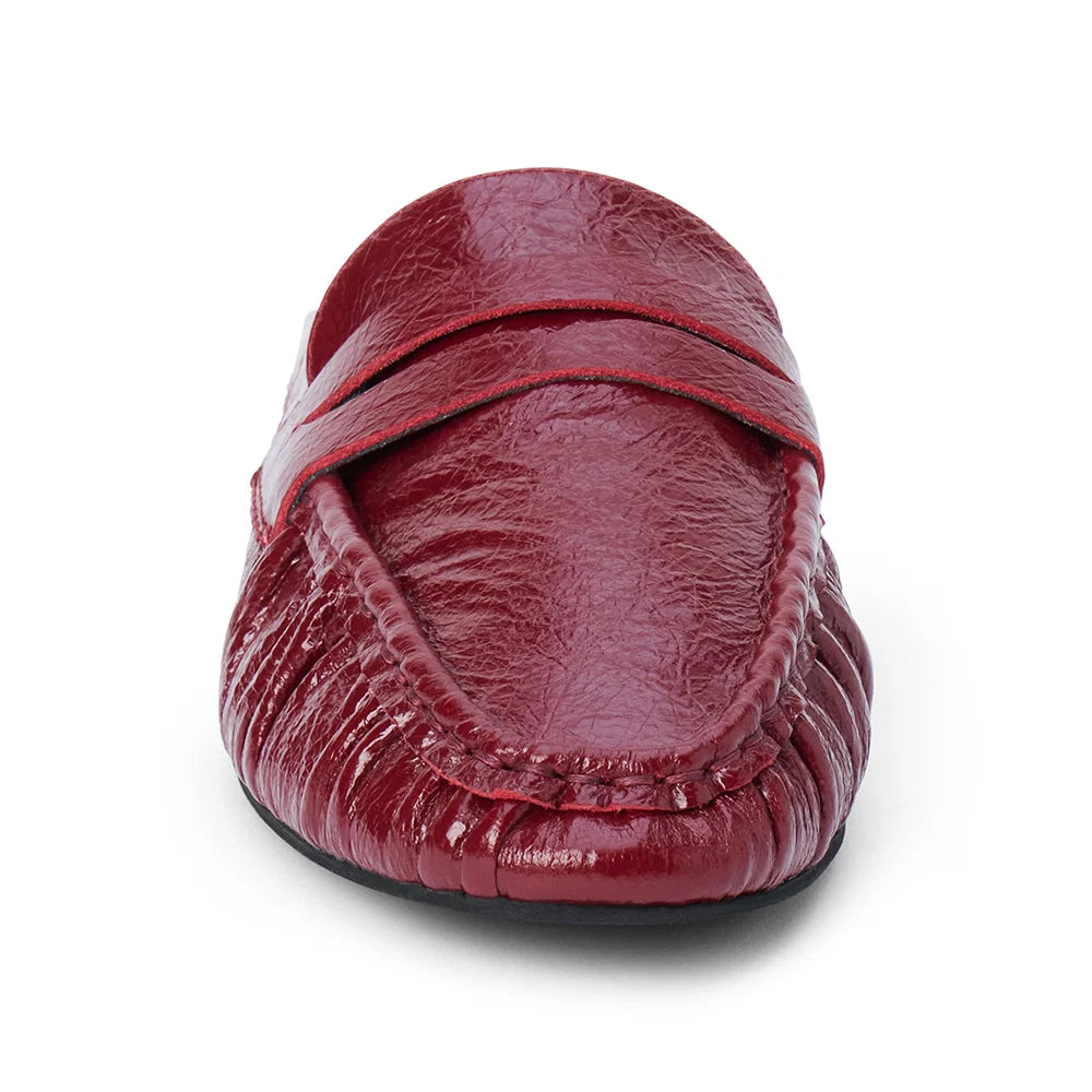 Front view of a glossy red leather penny loafer mule on a plain white background.