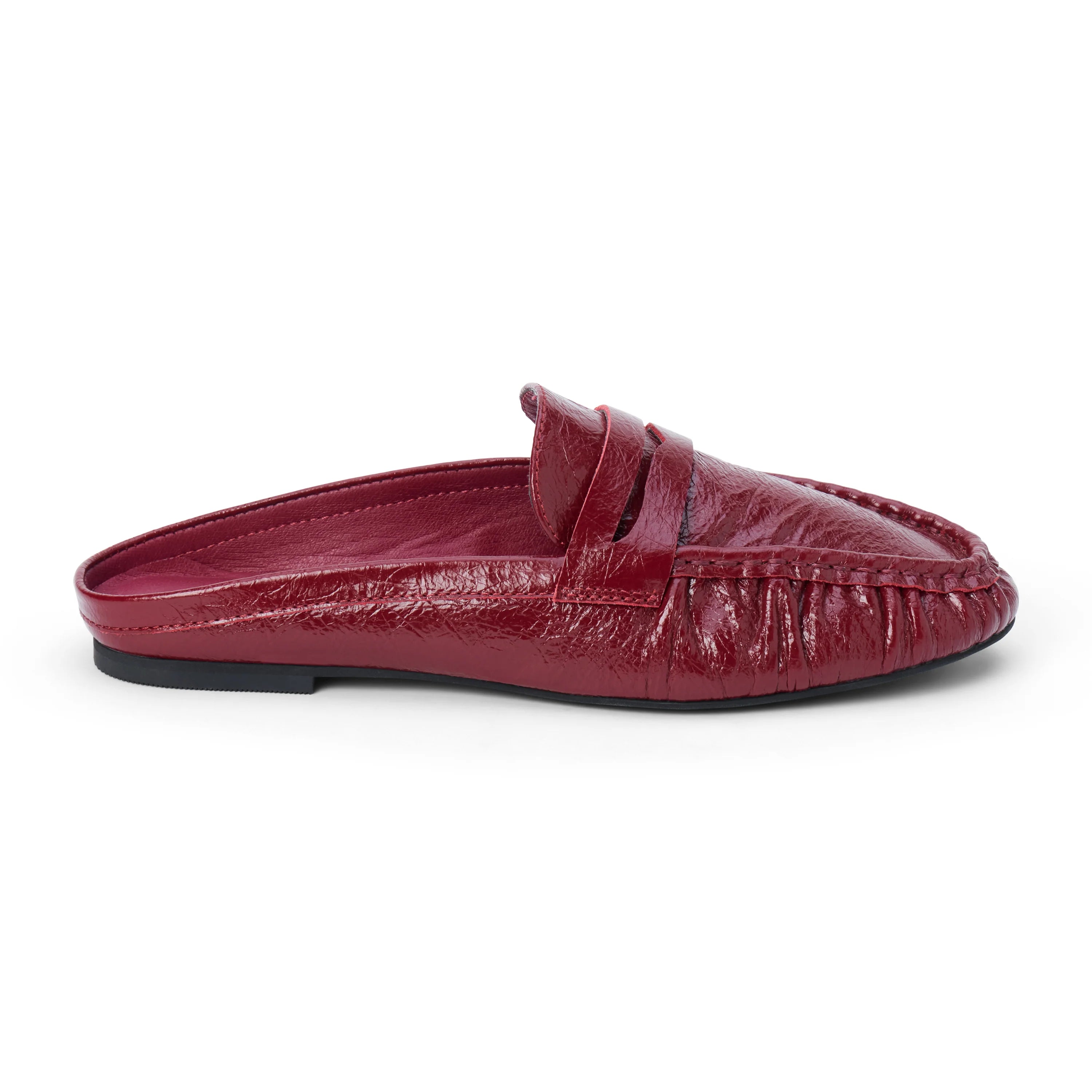 Side view of a glossy red leather penny loafer mule on a white background