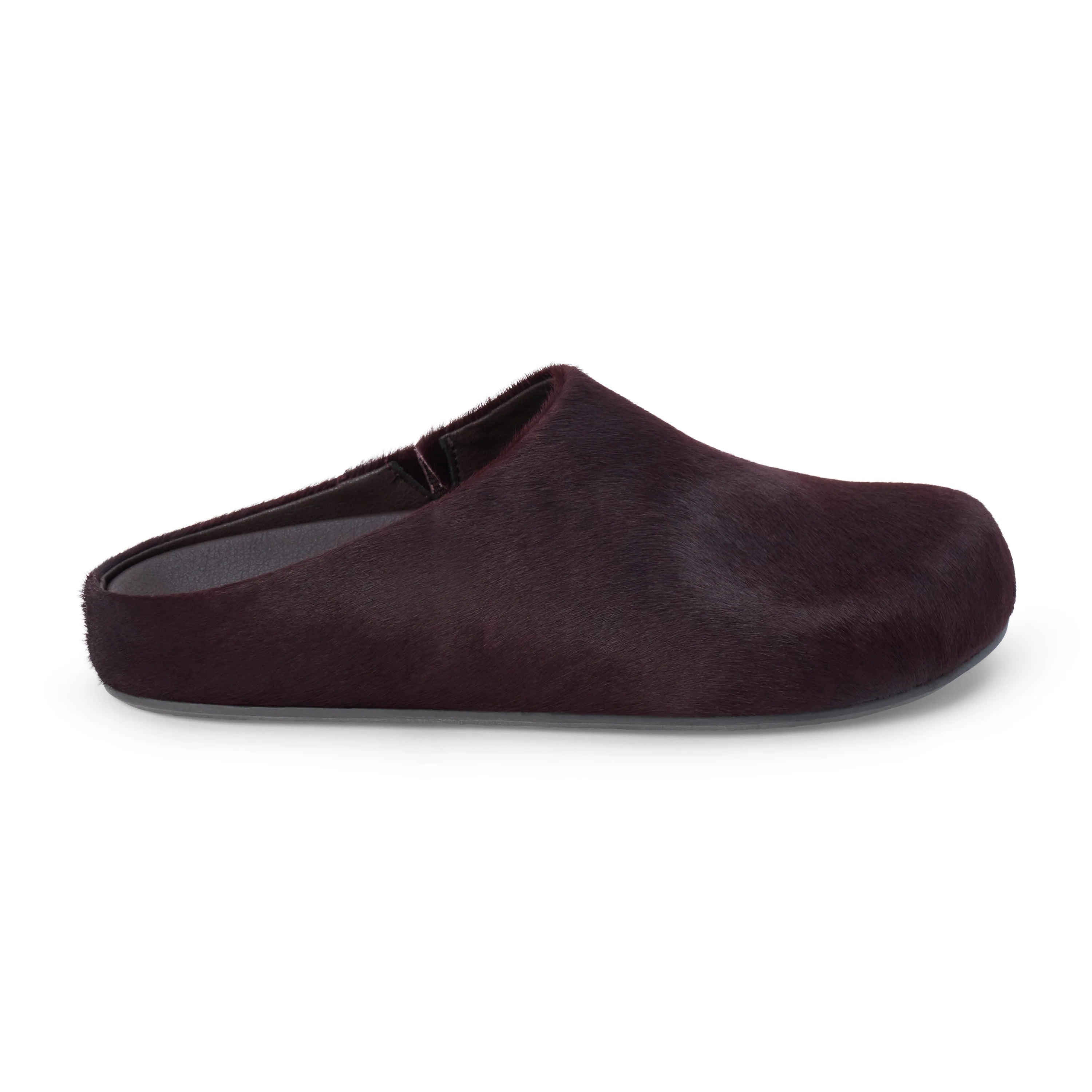 Pair of dark purple cow hair clog shoes on a white background
