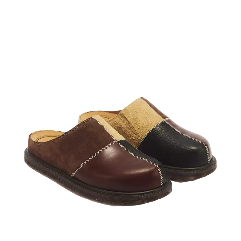 A pair of men's slip-on mule slippers in a color-blocked design, featuring dark brown suede, black leather, tan suede, and beige shearling lining, photographed on a white background.