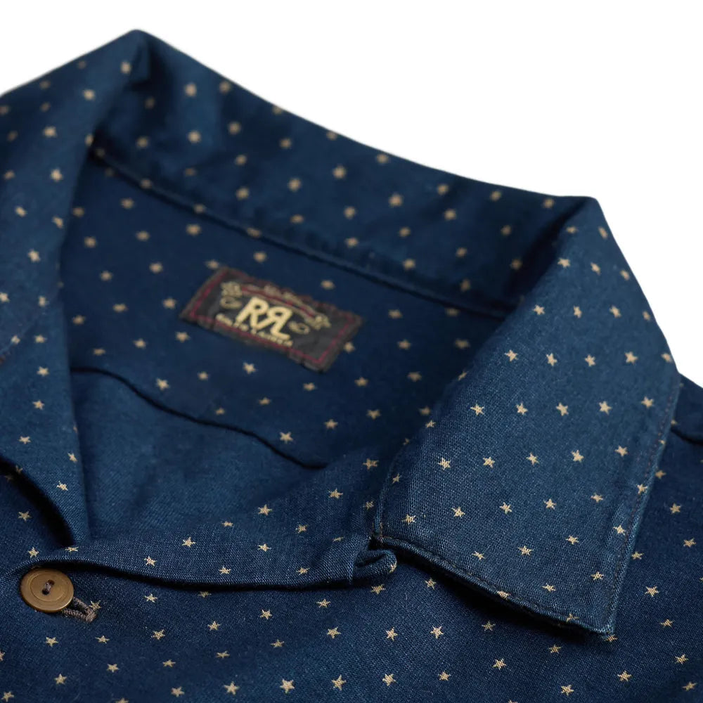 Close-up of a dark navy blue collared shirt with a small gold star pattern, featuring a brown button and a visible RRL neck label.