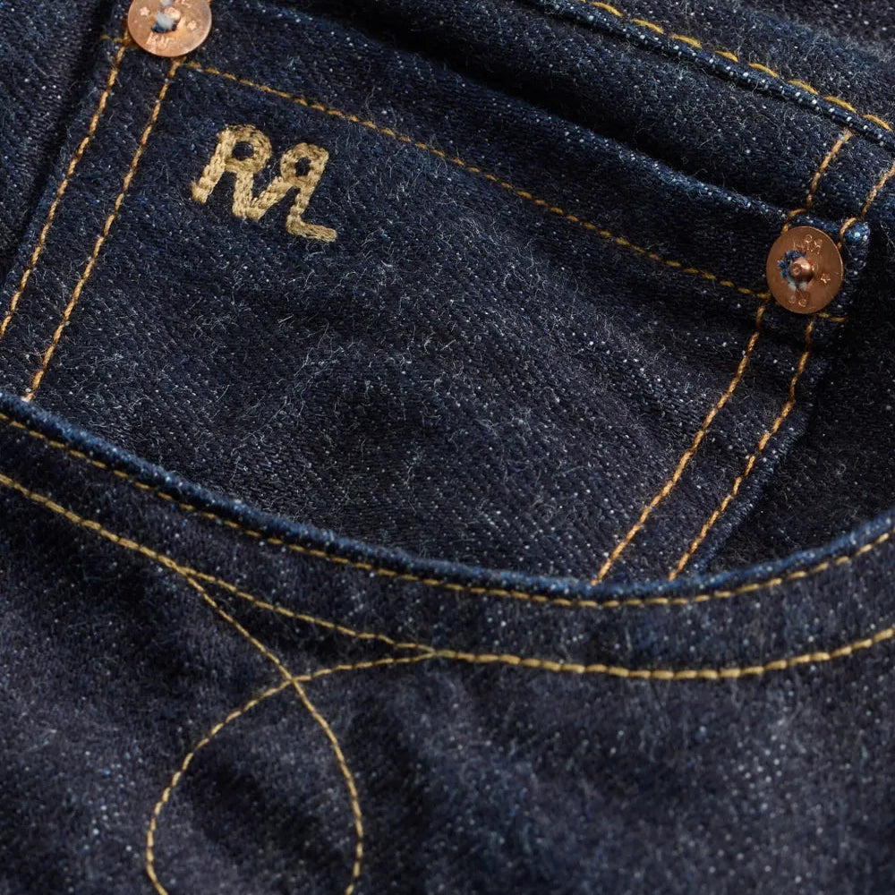 Close-up of a dark blue denim pocket with 'RL' branding.