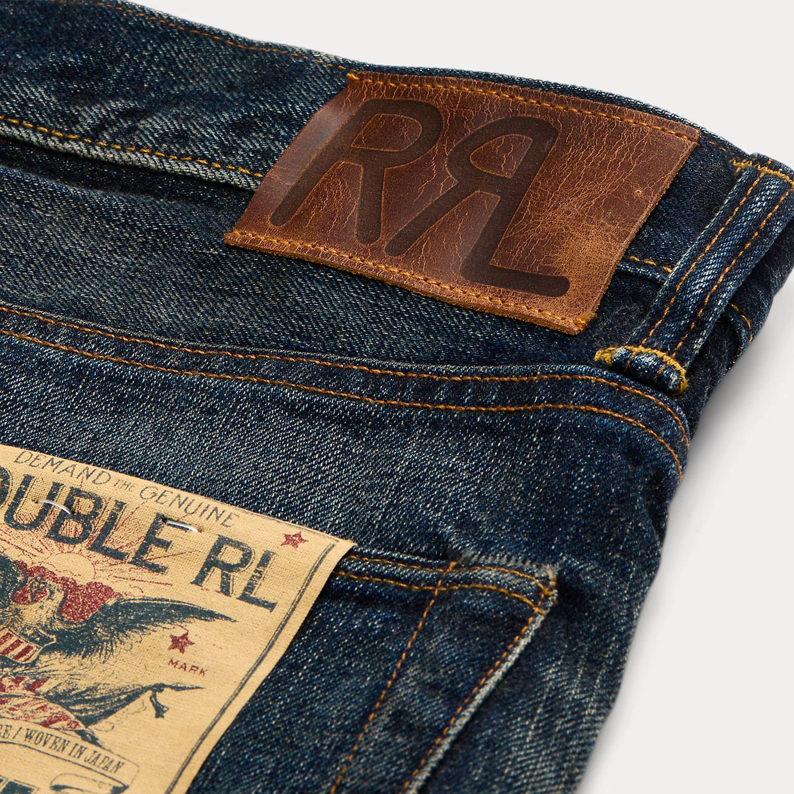 Close-up of blue jeans with a brown leather label and brand tag.
