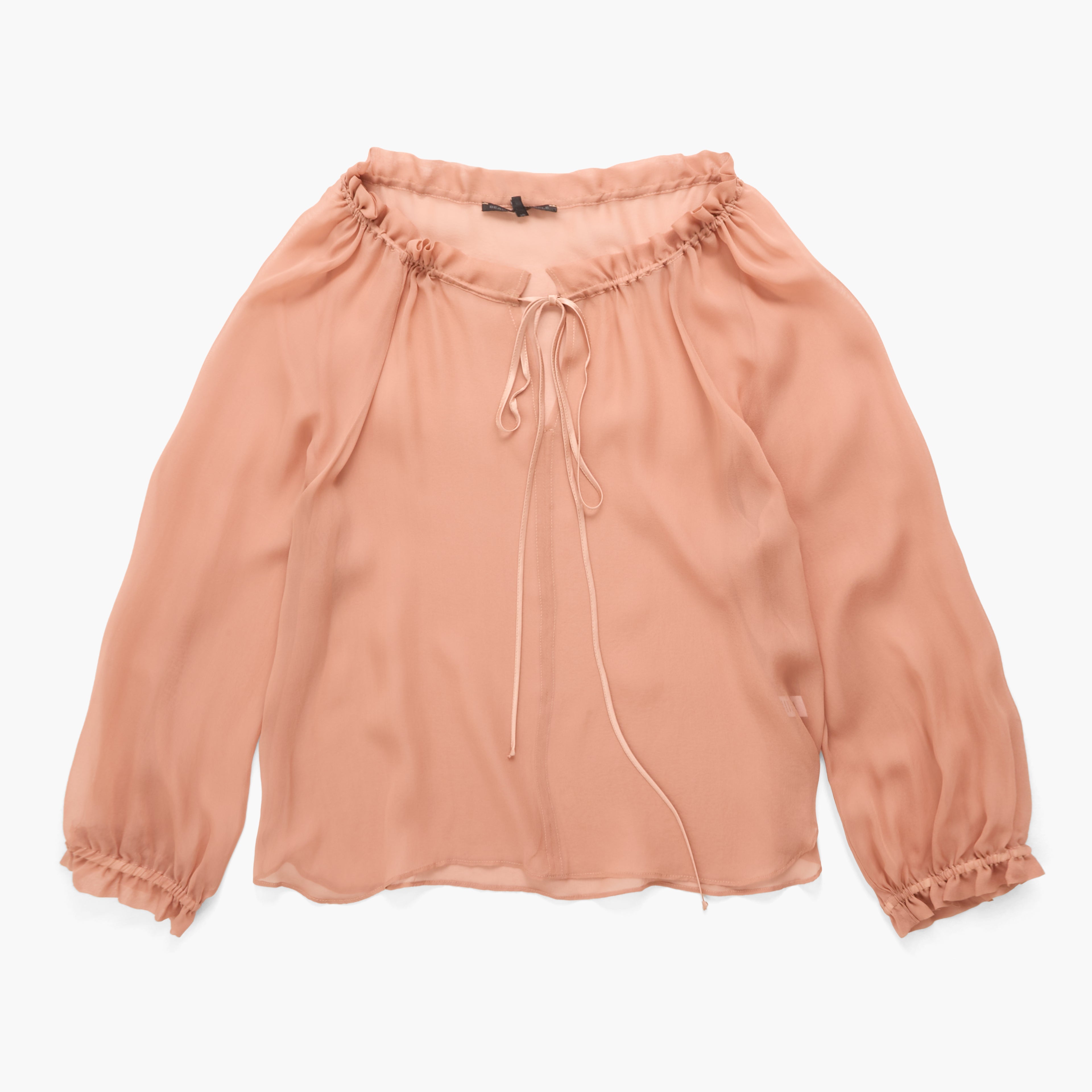 A peach-colored long-sleeve blouse with a ruffled off-the-shoulder neckline, a front tie detail, and gathered elastic cuffs, shown flat on a white background.