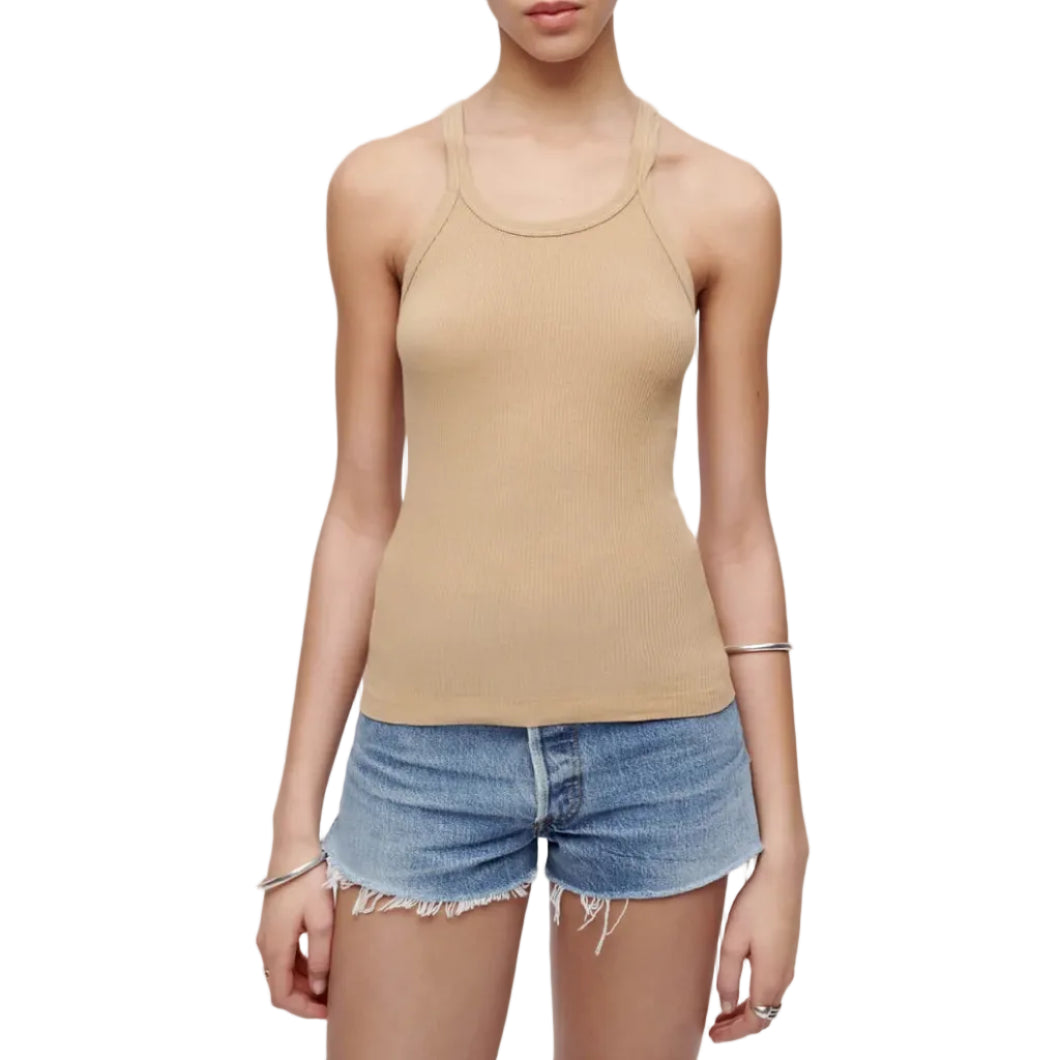 A model wearing a beige ribbed tank top and denim shorts, standing against a white studio background.