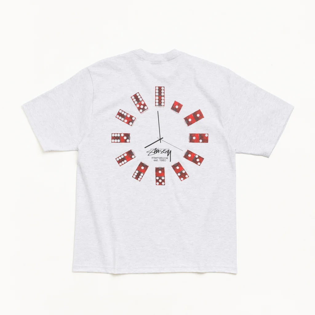 A light gray heather short-sleeve t-shirt with a creative graphic design on the back. The design uses domino tiles as hour markers for a clock face, with black clock hands and a small 'Stussy' brand signature printed below the center.