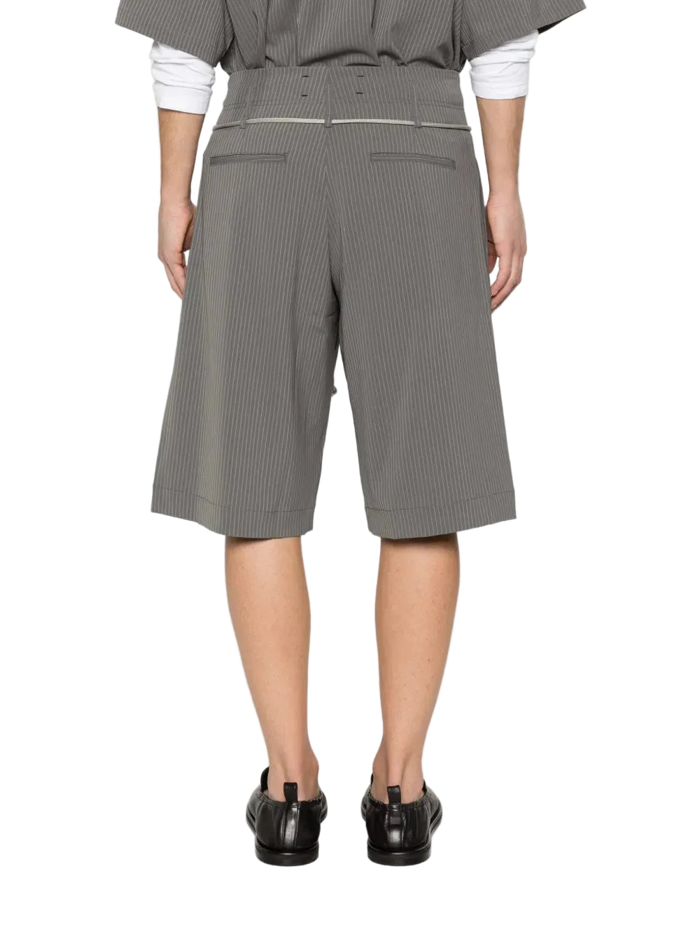 Person wearing gray pinstripe shorts on a white background