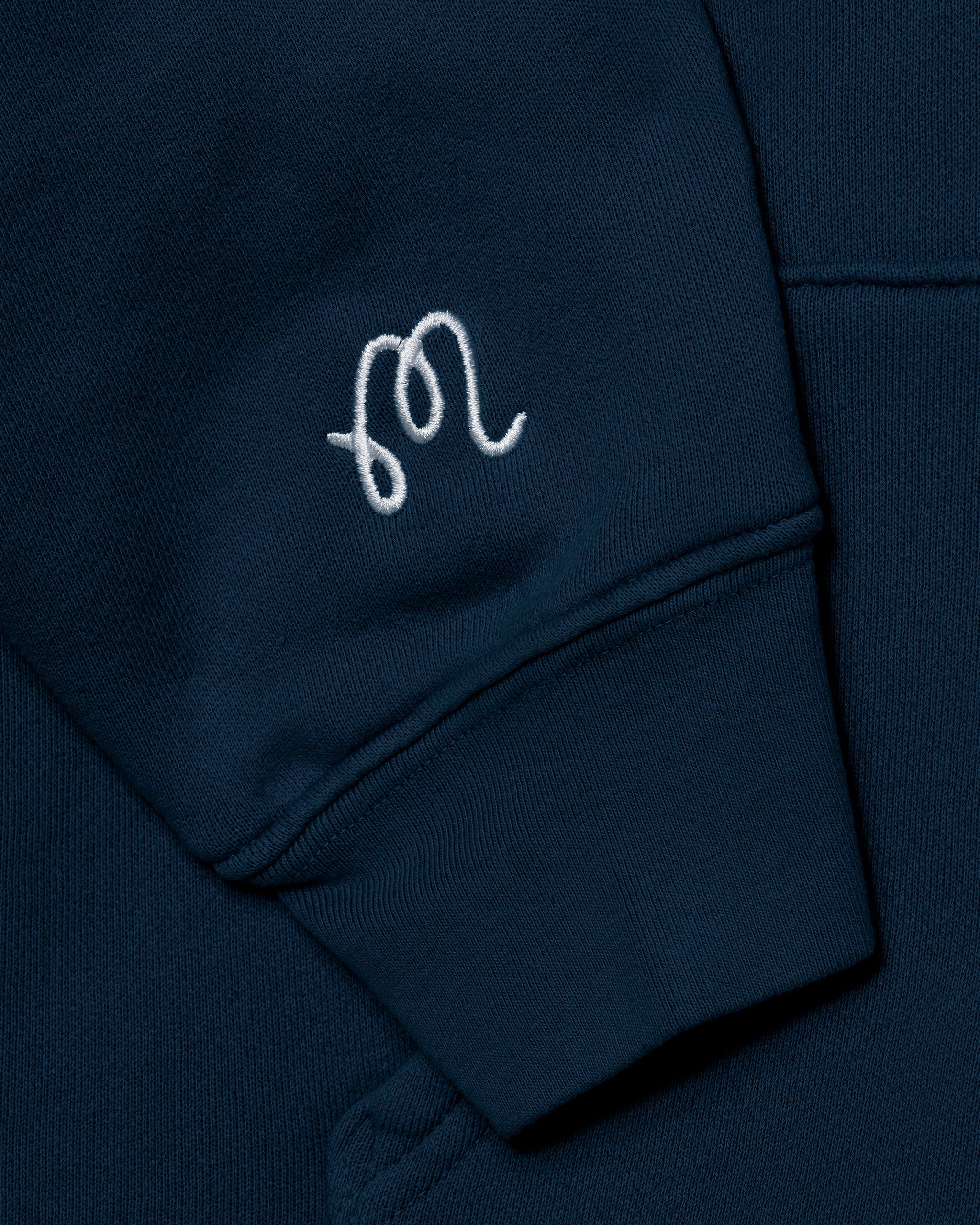 Navy blue sweatshirt with a white embroidered logo on the chest pocket.