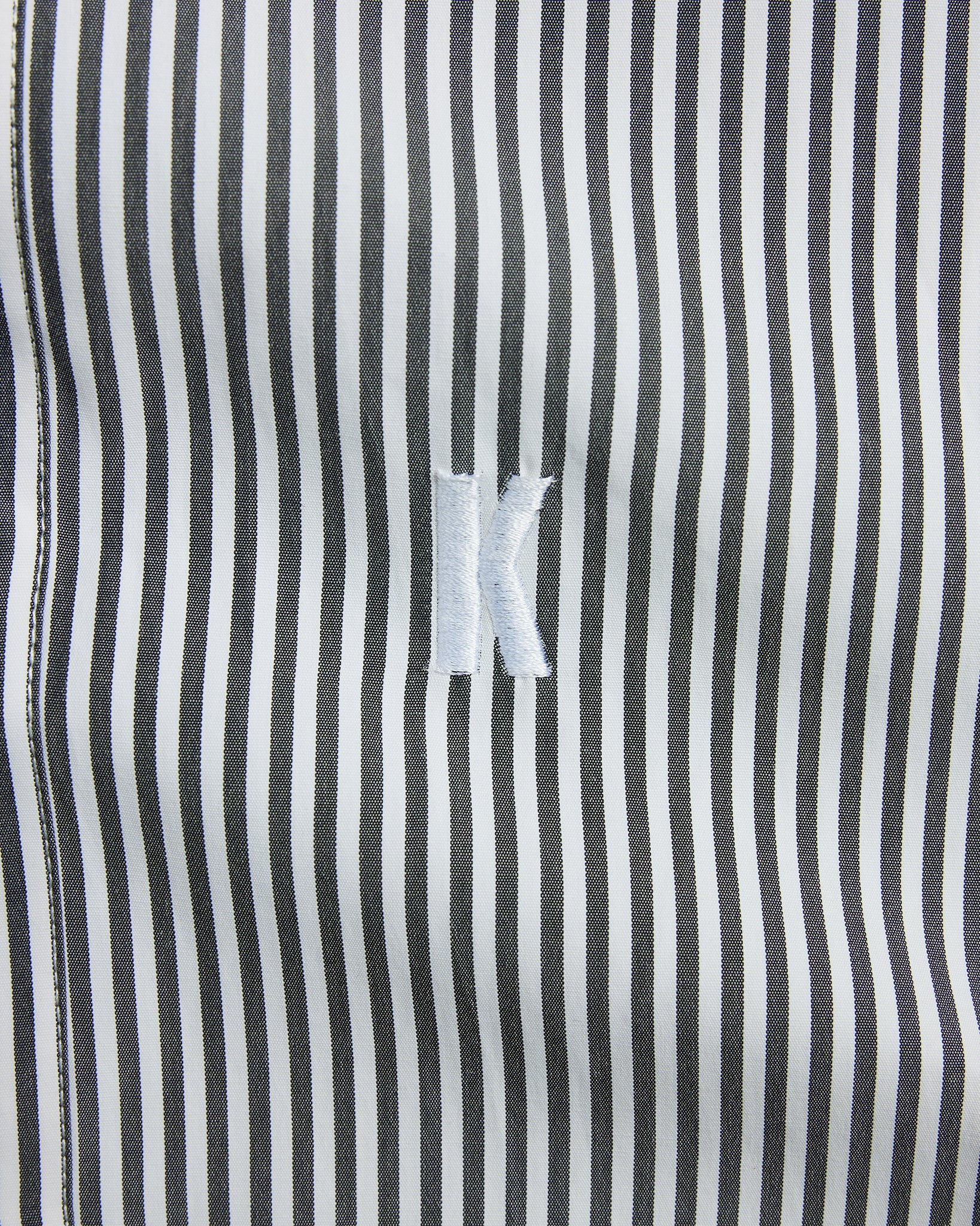 Close-up of a black and white striped fabric with a brand logo.