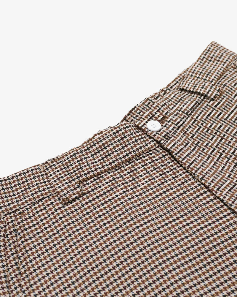 Close-up of a brown and black checkered fabric with a button on a light background