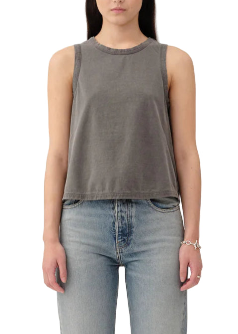 Person wearing a gray sleeveless top and light blue jeans on a white background