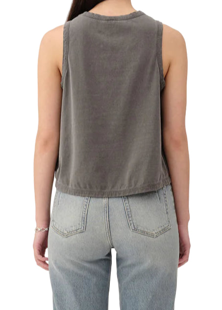 Person wearing a sleeveless gray top and light blue jeans on a white background