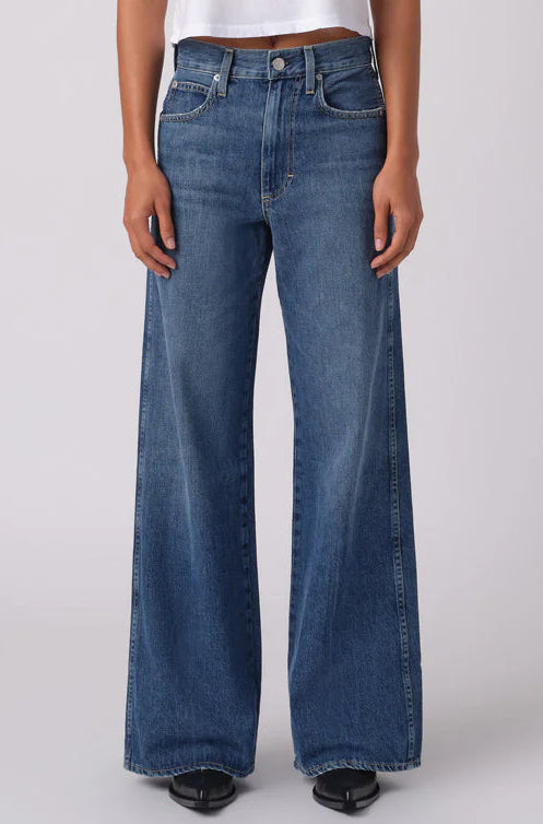 Person wearing a white t-shirt and blue jeans on a white background