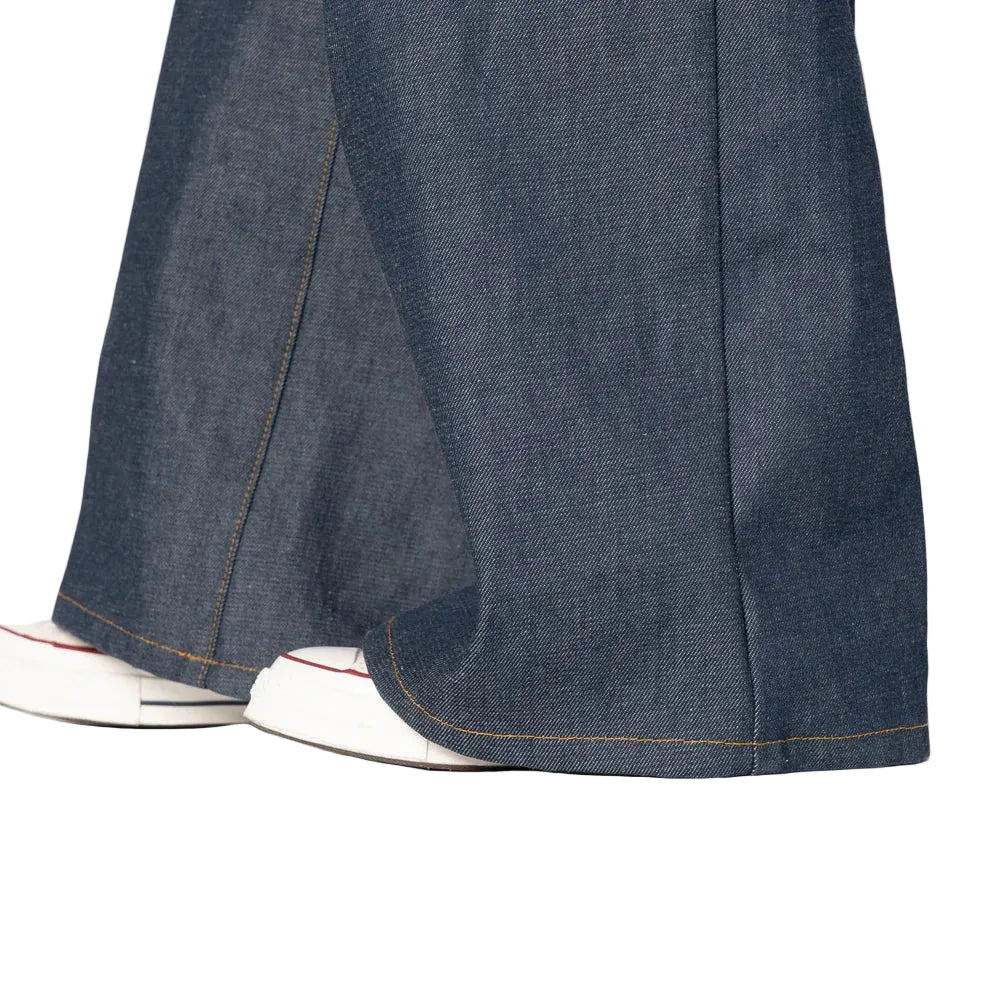 Close-up of blue denim pants with white sneakers on a light gray background