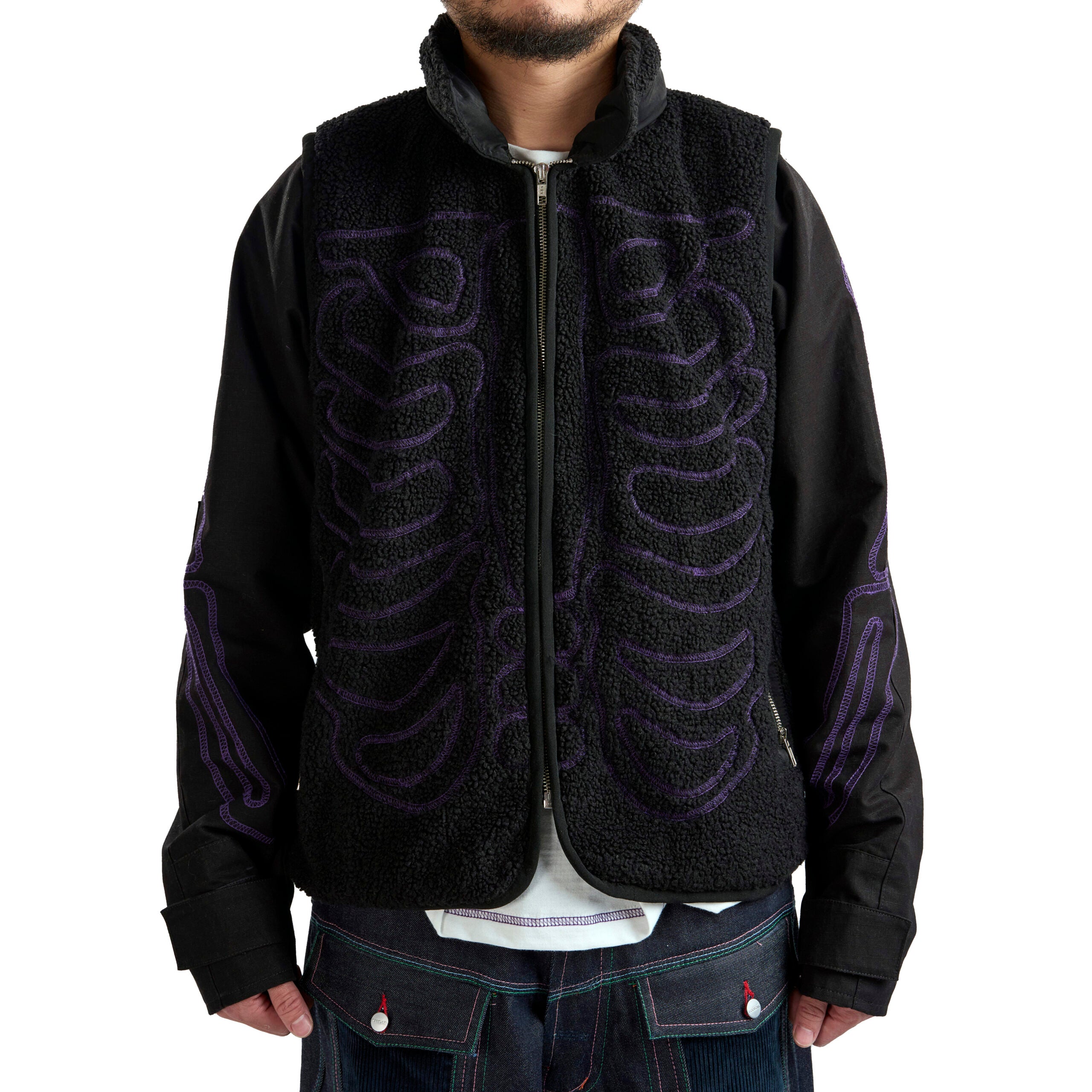 Black jacket with purple tribal patterns worn by a person on a white background