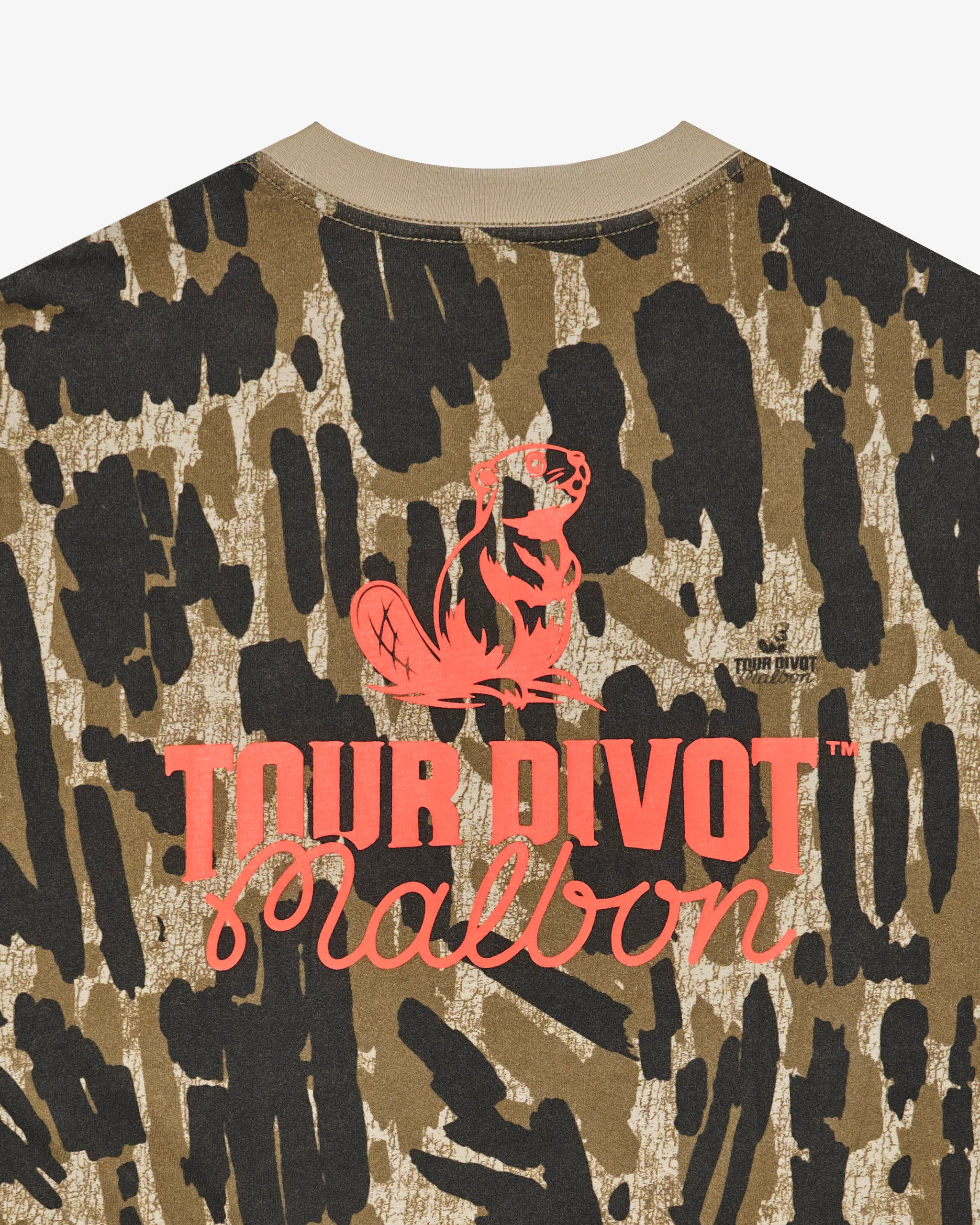 Camouflage-patterned shirt with 'Tour Divot' logo on a white background