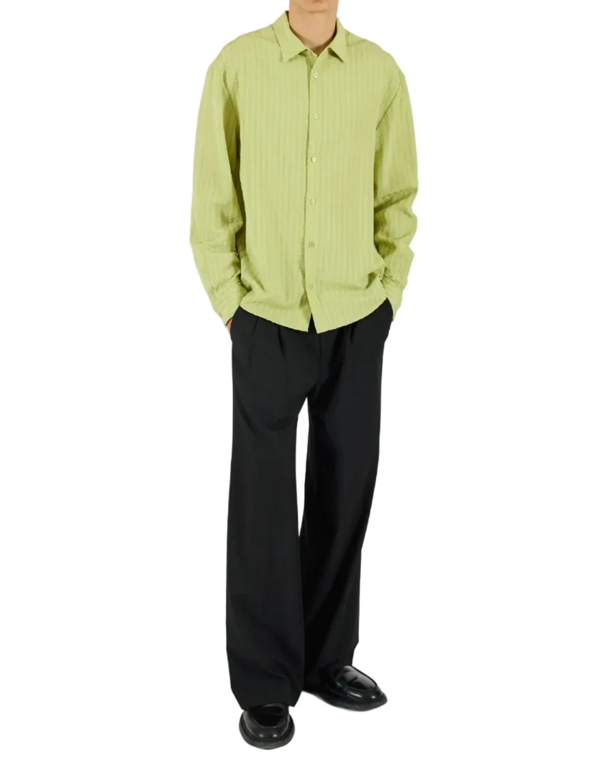 Person wearing a light green checkered shirt and black pants on a white background