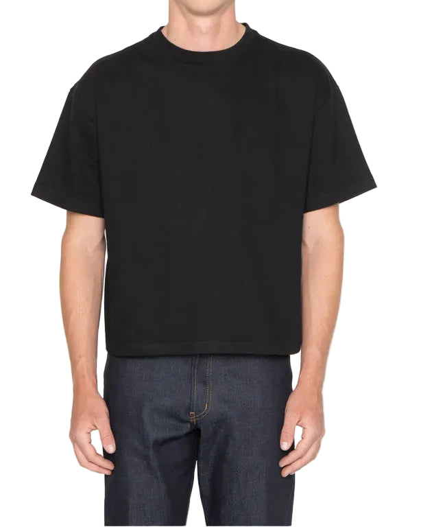 Person wearing a black t-shirt and dark pants on a white background