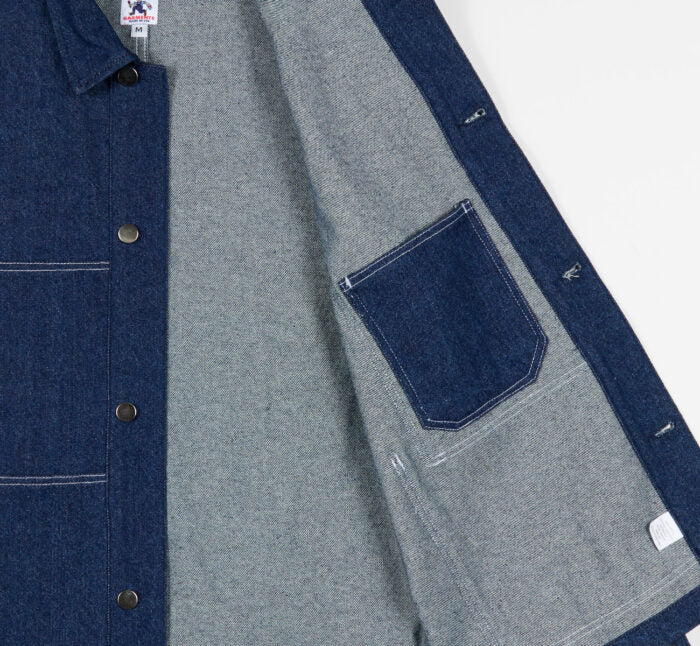 Close-up of an indigo denim jacket interior pocket on a white background