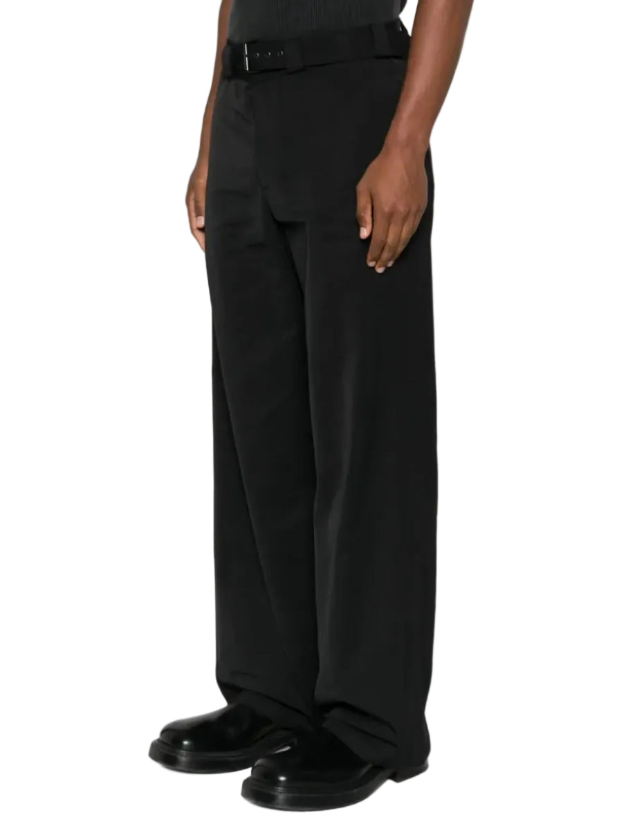 Person wearing black pants and shoes on a white background